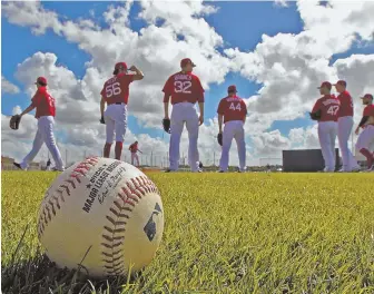  ?? STaFF PhOTO by MaTT sTONe ?? FIELD DAY: Red Sox pitchers wait their turn during a drill at spring training yesterday in Fort Myers.