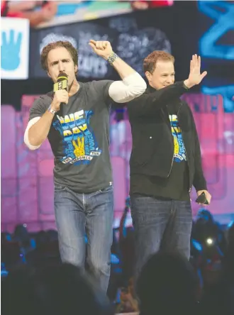  ?? HANNAH YOON / THE CANADIAN PRESS FILES ?? Craig Kielburger and Marc Kielburger, shown here during a Toronto WE Day in 2014, were surprised to hear their organizati­on had been chosen to administer a summer jobs program.