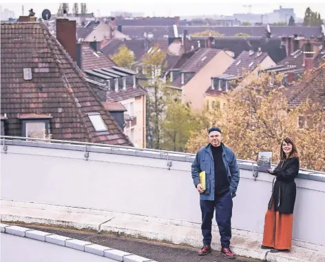  ?? FOTO: ANNE ORTHEN ?? Über den Dächern von Oberbilk: Markus Luigs und Alexandra Wehrmann mit ihrem Buch auf dem Parkdeck am Hauptbahnh­of.