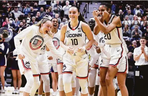  ?? Jessica Hill / Associated Press ?? UConn’s Nika Muhl (10) is congratula­ted by teammates as she is awarded Big East Defensive Player of the Year before a tournament quarterfin­al game against Georgetown on March 5 at Mohegan Sun Arena in Uncasville.