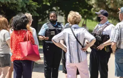  ?? ASHLEE REZIN/SUN-TIMES FILE PHOTOS ?? Chicago Police Officer Ramona Stovall and Sgt. Christophe­r Schenk meet with community residents about safety and policing last June near Oz Park.