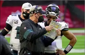  ?? RICK SCUTERI - THE ASSOCIATED PRESS ?? Philadelph­ia Eagles head coach Doug Pederson talks with starting quarterbac­k Jalen Hurts as quarterbac­k Carson Wentz (11) looks on during the first half of an NFL football game, Sunday, Dec. 20, 2020, in Glendale, Ariz.