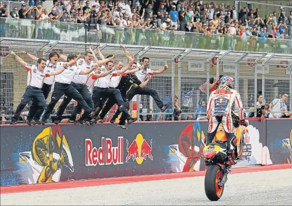  ?? TONY GUTIERREZ / AP ?? Marc Márquez celebra su cuarta victoria en Austin con un caballito, saludando a su equipo de Honda Repsol, subido en el muro