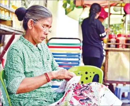  ?? ALASTAIR MCCREADY ?? A woman sews a quilt on the street in Phnom Penh. While the plight of Iranian women was brought into the spotlight once again by a recent World Cup qualifier football match against Cambodia, the return fixture presents an opportunit­y to reflect on the current state of affairs for the women residing almost 6,000km away in the Kingdom.