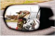  ?? MARK HUMPHREY / AP ?? A National Guard soldier directing drivers is reflected in the mirror of a car waiting in a vaccinatio­n line in Shelbyvill­e, Tenn. Tennessee has continued to divvy up doses based on how many people live in each county.