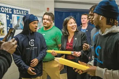  ?? JERRY JACKSON/BALTIMORE SUN ?? Acting U.S. Department of Labor Secretary Julie Su reacts after being given an oversized pencil by students at Carver Vocational Technical High School during a tour.