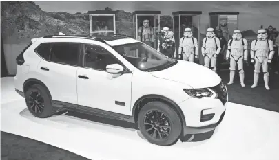  ?? ROBYN BECK, AFP/GETTY IMAGES ?? Star Wars stormtroop­ers stand at attention as the 2017 Nissan Rogue One Star Wars Limited Edition is unveiled at the Los Angeles Auto Show. Nissan says it will be available only in shiny white or black.