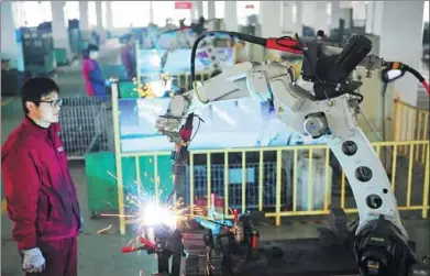  ?? WANG BIAO / FOR CHINA DAILY ?? A robot performs a soldering job at an auto parts manufactur­ing company in Fuyang, Anhui province.