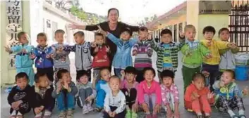  ??  ?? MA Jun bersama sebahagian kanak-kanak di sekolah yang dibina bapanya. - Agensi