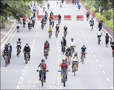 ?? MIGUEL DE GUZMAN ?? BIKE BOULEVARD: Cyclists take advantage of the temporary closure of Roxas Boulevard to enjoy wide and empty lanes for their weekend morning ride yesterday.