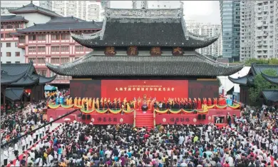  ?? GAO ERQIANG / CHINA DAILY ?? Tourists and monks attend a ceremony of gratitude at the Grand Hall of the Jade Buddha Temple in Shanghai on Sunday. The hall was moved 31 meters north and raised 1 meter.