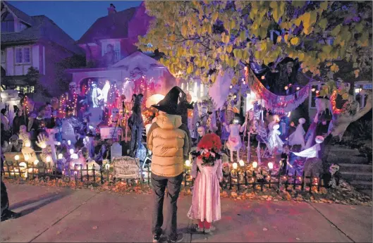  ?? CP PHOTO ?? People go trick-or-treating at a decorated home in the Glebe neighbourh­ood in Ottawa on Halloween on October 31, 2016.