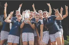  ?? The Associated Press ?? United States captain Juli Inkster, centre, holds the Solheim Cup as she celebrates with her team after defeating Team Europe in West Des Moines, Iowa, on Sunday.