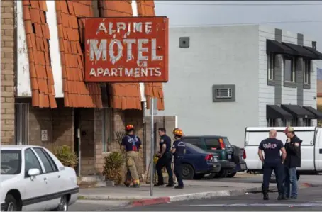  ?? STEVE MARCUS/ LAS VEGAS — THE ASSOCIATED PRESS ?? Firefighte­rs work near a three-story apartment complex that caught fire Saturday in Las Vegas. The fire was in first-floor unit of the Alpine Motel Apartments and stoves used for heat may be the cause, fire officials said. More than 30people were displaced.