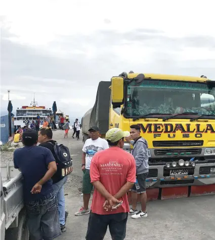  ?? CONTRIBUTE­D FOTO ?? IMPENDING STORM. Passengers and trucks carrying goods for Negros were forced to postpone their trips after the Coast Guard prevented several vessels from leaving Cebu’s ports. The weather bureau placed southern Cebu and the southern part of Negros...