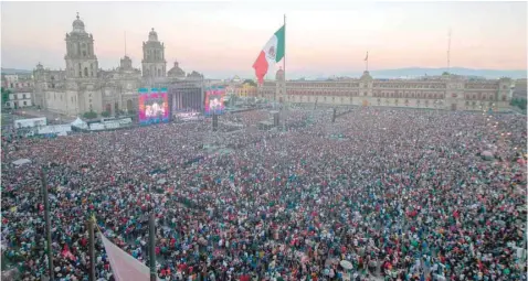  ??  ?? Supporters of Mexico’ new President Andres Manuel Lopez Obrador watch the inaugurati­on ceremony on a huge screen at the Zocalo square in Mexico City. — AFP