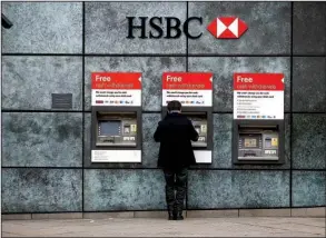  ?? Bloomberg News/SIMON DAWSON ?? A customer Monday uses an ATM outside a London branch bank of HSBC Holdings Plc, a multinatio­nal banking and financial services company based in that city that is tied to a secret account in Switzerlan­d held by a family member of a former Chinese...