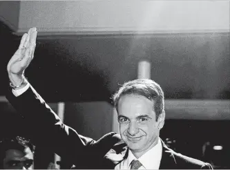  ?? PETROS GIANNAKOUR­IS THE ASSOCIATED PRESS ?? Greek opposition New Democracy party leader Kyriakos Mitsotakis waves to supporters in Athens after winning the parliament­ary election Sunday. He beat Prime Minister Alex Tsipras.