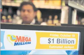  ?? RAY CHAVEZ — STAFF PHOTOGRAPH­ER ?? The $1 billion estimated jackpot for the Mega Millions lottery reached a new record as its shows at King’s Liquors groceries in Oakland on Friday.