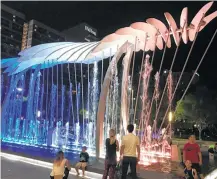  ?? Molly Glentzer / Houston Chronicle ?? Visitors to downtown take in the “Wings over Water” sculpture that’s installed within a fountain in front of the George R. Brown Convention Center.