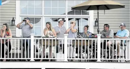  ?? —PHOTOS FROM AP ?? PRIVILEGED FEW With no fans allowed at TPC River Highlands, these lucky ones witness the action from a member’s fairway home.