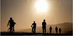  ??  ?? Beachgoers jog and bike at sunset along the trail at Santa Monica beach. AFP PHOTO / FREDERIC J. BROWN