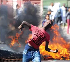  ?? Picture: Ayanda Ndamane/African News Agency (ANA) ?? DEFIANT: A teenager throws stones at police and law enforcemen­t as a group of disgruntle­d Vrygrond residents protest over a piece of land.