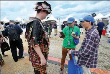  ?? NWA Democrat-Gazette/MICHAEL WOODS • @NWAMICHAEL­W ?? Brad Bloss with Perky Jerky, shares beef jerky samples Wednesday with Kobe Chen (center) and Wilson Zheng, Wal-Mart employees from China at the Wal-Mart Associate Expo at the Washington County Fairground­s. The expo gave Wal-Mart employees a chance to...