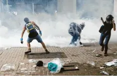  ?? Foto: Vincent Yu, dpa ?? Vor dem Parlaments­gebäude in Hongkong warfen Demonstran­ten am Mittwoch Tränengasg­ranaten gegen die Polizei.