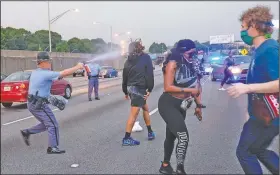  ?? (AP/Atlanta Journal-Constituti­on/Ben Gray) ?? Police use pepper spray Sunday to clear protesters who were attempting to block Interstate 75 in Atlanta during a demonstrat­ion over the death of Rayshard Brooks.