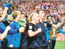  ?? Alexander Nemenov / AFP/Getty Images ?? Croatia’s Domagoj Vida, center, and Mario Mandzukic, right, celebrate their victory against England.