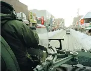  ?? THOMAS CHENG / AFP / GETTY IMAGES FILES ?? Claudia and Duncan Wood ski down a Toronto street after the city’s third major snowstorm in January of 1999. Right: Canadian Army officer John Dunn patrols downtown Toronto in an armoured personnel carrier after the storm.