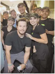  ?? PHOTO BY ERIK KABIK/ERIK KABIK PHOTOGRAPH­Y ?? WANT FRIES WITH THAT? Mark Wahlberg poses with the staff of Wahlburger­s Las Vegas, the latest addition to the burger chain.