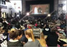  ?? ANDREW DALTON - THE ASSOCIATED PRESS ?? Students and their families watch the wedding of Prince Harry and Meghan Markle in the gym of Immaculate Heart High School, Markle’s alma mater, early Saturday, in Los Angeles.