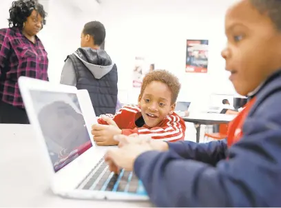  ?? JONATHON GRUENKE/STAFF ?? ABOVE: Davion O’Neal, center, smiles as he watches Davion Brown use a computer in the lab at the Boys and Girls Club in Hampton onFeb. 7.