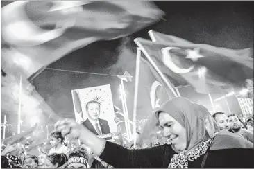  ?? OZAN KOSEOZAN KOSE/AFP/GETTY IMAGES ?? Supporters hold a portrait of Turkey’s President Recep Tayyip Erdogan and wave national flags during a rally in Istanbul. A decree published Saturday will close more than 2,000 organizati­ons linked to the alleged mastermind of last week’s failed coup.