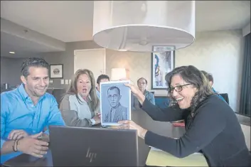  ?? PHOTOS BY BRITTAINY NEWMAN — THE ASSOCIATED PRESS ?? Anna Salton Eisen holds up a photo of Emil Ringel, father of Barbara Ringel, for a Zoom video call during a gathering for families of Holocaust survivors in East Brunswick, N.J., on Sunday.