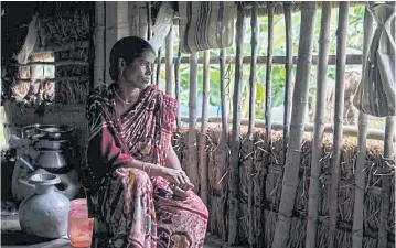  ??  ?? Geeta Mridha, who lost her husband to a tiger attack, sits in her home in Lahiripur, India.