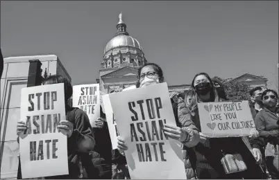  ?? BEN GRAY AP PHOTO ?? People hold signs while participat­ing in a “stop Asian hate” rally outside the Georgia State Capitol in Atlanta on Saturday.