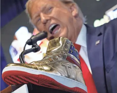  ?? CHIP SOMODEVILL­A/ GETTY IMAGES ?? Former President Donald Trump introduces his signature shoes at “Sneaker Con” in Philadelph­ia on Saturday. The sneakers are being marketed as “Never Surrender High-Tops” and selling for $399. The first 1,000 pairs already have sold out.