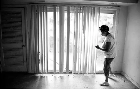  ?? — WP-Bloomberg photos ?? Johnson, a recipient of a rapid rehousing voucher, walks through an empty apartment that has no locks on the door. Tenants in a number of buildings managed by Sanford Capital have sued the company due to the condition of their buildings.