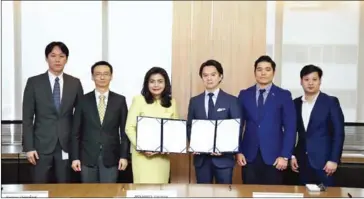  ?? THE NATION ?? Surangkana Wayuparb (third from left), executive director of ETDA, under the Ministry of Digital Economy and Society, displays a memorandum of understand­ing with Jun Hasegawa, a co-founder of Omise, relating to work on the National Digital Identity...