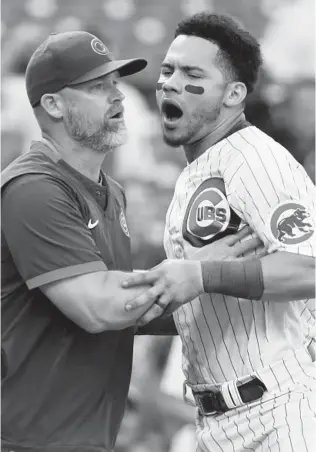  ?? JOHN J. KIM/CHICAGO TRIBUNE ?? Catcher Willson Contreras is held back by manager David Ross on Saturday.