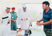  ??  ?? Brigadier Sultan Yusuf Al Nuaimi checks the applicatio­n of one of the amnesty-seekers in Ras Al Khaimah. — Supplied photo