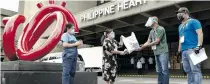  ??  ?? n Philippine Heart Center’s Chief Administra­tive Officer Emilia Maralit receives a food pack from Public Assistance Officer II Ferdinand Marcos 2nd Amador of Pagcor’s Community Relations and Services Department during the ceremonial turnover at their hospital on April 12.