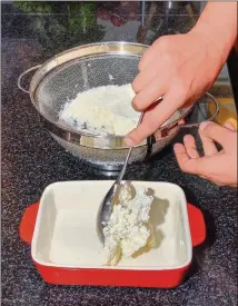  ??  ?? Gauri Misra-Deshpande scoops drained paneer into an appropriat­e size container for covering and refrigerat­ion.