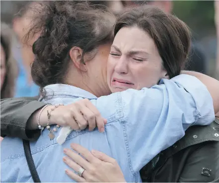  ?? David Moll/For the Calgary Herald ?? Jennifer O’Brien is consoled at a candleligh­t vigil for her missing son and his grandparen­ts at the Parkhill Community Centre on Thursday.