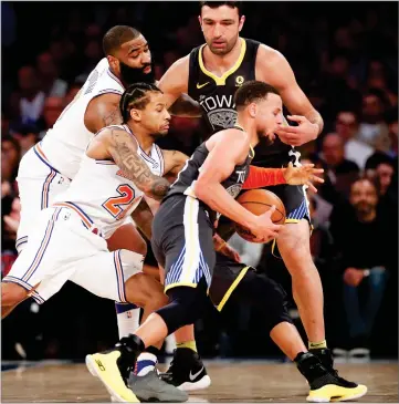  ?? AP PHOTO BY KATHY WILLENS ?? New York Knicks center Kyle O’quinn, left, and guard Trey Burke, second from left, try to strip the ball from Golden State Warriors guard Stephen Curry, front right, as Warriors center Zaza Pachulia watches, back right, during the second half of an NBA...