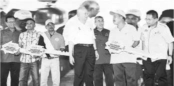  ?? Bernama photo ?? Prime Minister Datuk Seri Najib Tun Razak presenting key replica at the opening the Muafakat Kedah Fishermen’s Housing Estate in Tanjung Dawai, Kedah. -