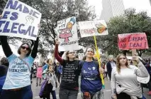  ??  ?? Danielle Baeter of Houston, left, Emma Lapen, with her mother, Erica, and Amber Lindsey, 16, right, all of Sugar Land, joined the throng at Saturday’s rally at City Hall.